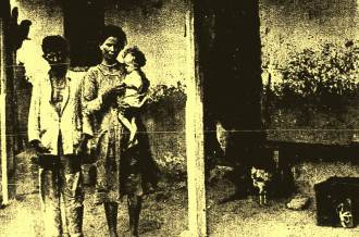 Joaquim Gomes Cardoso, sua esposa e filho diante de sua casa no lugar Passagem.
