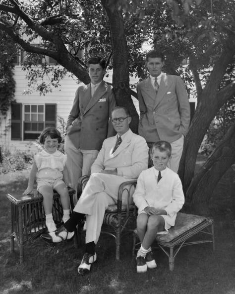 Young-JFK-with-double-breasted-combination-collar-pin-with-father-Joe-and-siblings